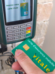 Une carte vitale devant un lecteur